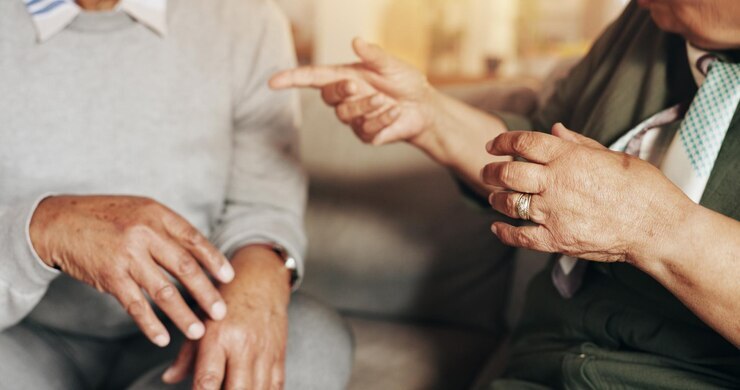 A photograph of two people having a conversation, zoomed in close on their hands