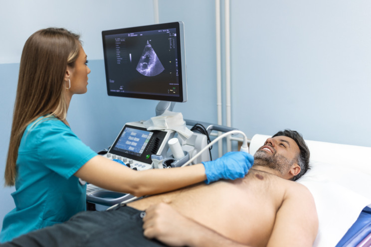 Photo of a healthcare professional performing an echocardiogram.
