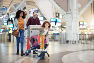 A photo of a family in an airport with their luggage.