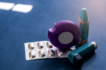 photograph of asthma medications including pills in foil and inhalers.