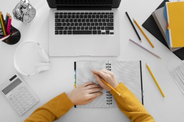 A photo of someone writing at a desk.
